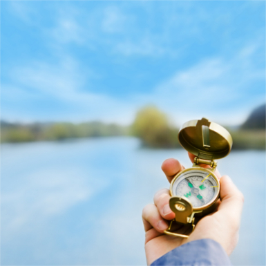 compass in hand on landscape background
